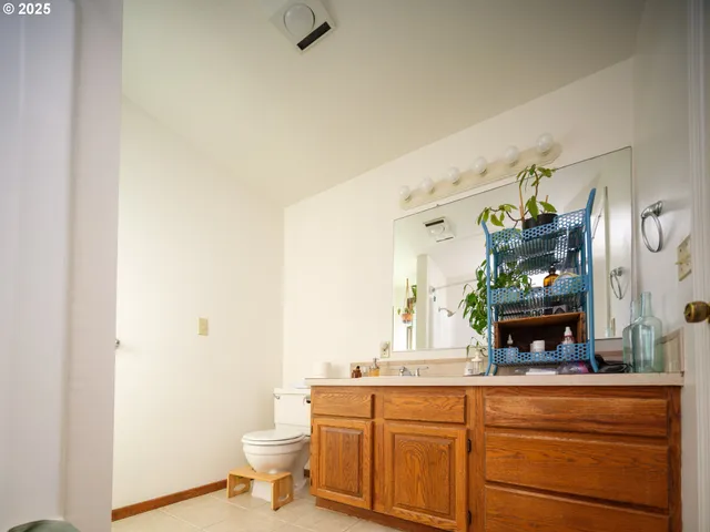 a bathroom with a toilet a sink and mirror