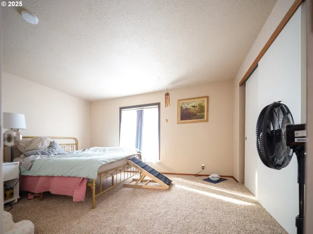 a bedroom with a bed a couch and a window