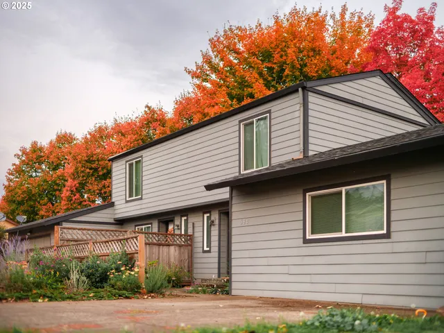 a front view of a house with garage and plants