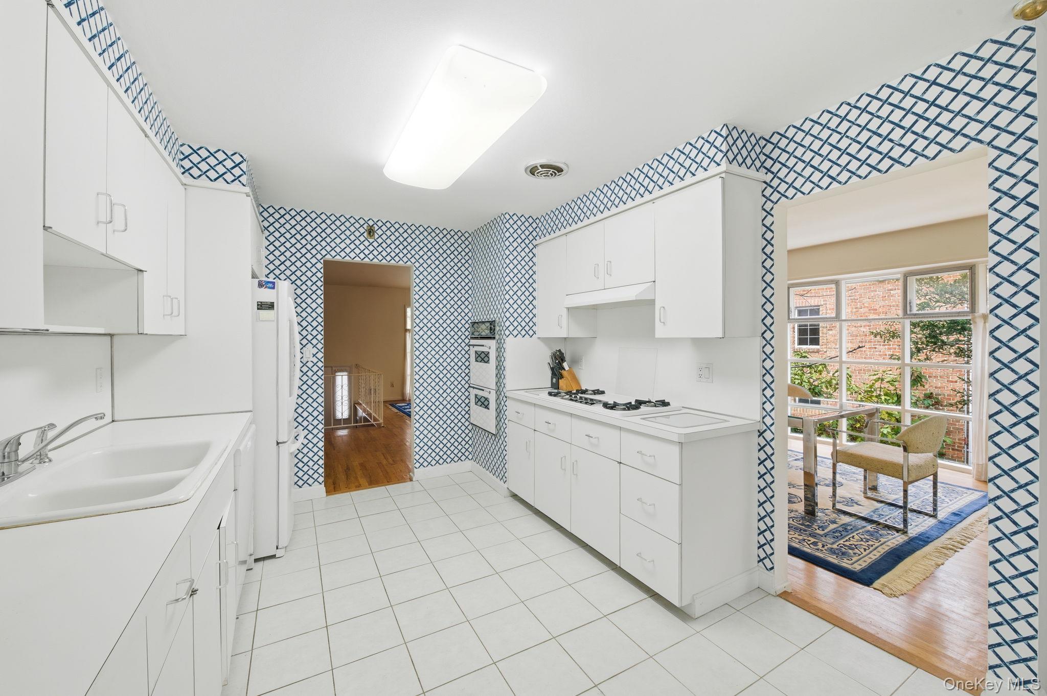 18 Dunhill Road Manhasset Hills, NY 11040 - Photo 7 of 20 a kitchen with white cabinets and appliances
