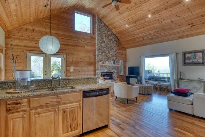 2081 Gallatin Road Young Harris, GA 30582 - Photo 11 of 44 a kitchen with stainless steel appliances granite countertop a sink dishwasher a dining table and chairs with wooden floor