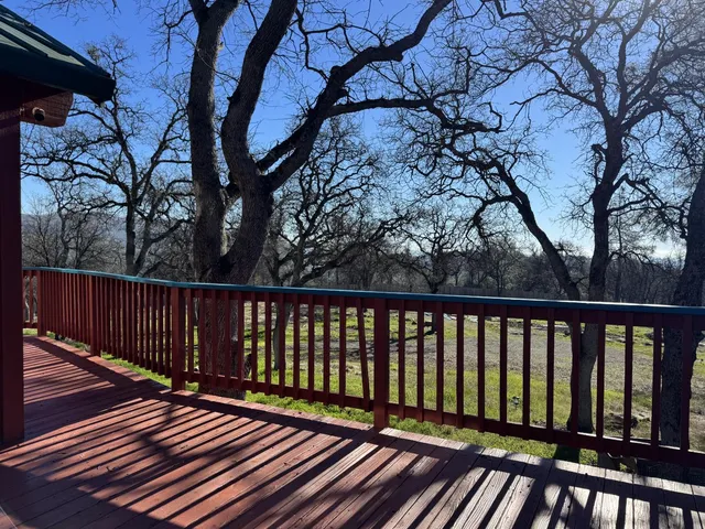 a view of a balcony with wooden floor and fence