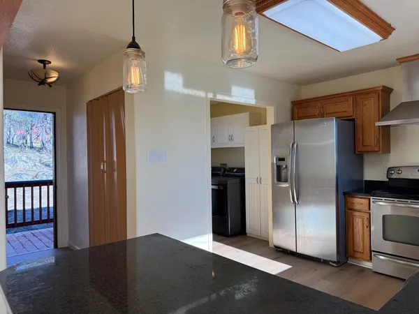 a kitchen with stainless steel appliances granite countertop a refrigerator a sink and a stove