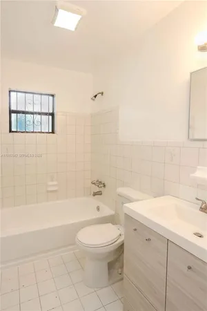 a bathroom with a toilet a sink a mirror and bathtub