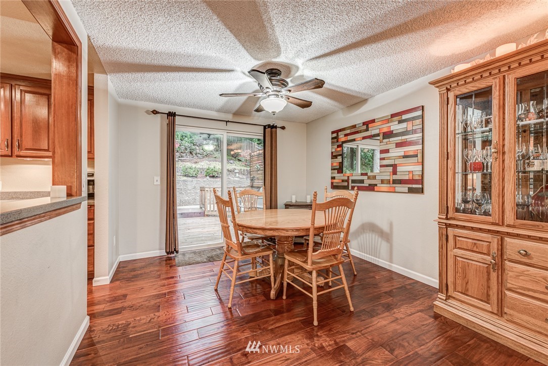 2001 172nd Place Southeast Bothell, WA 98012 - Photo 11 of 32 a dining room with wooden floor a chandelier a wooden table and chairs