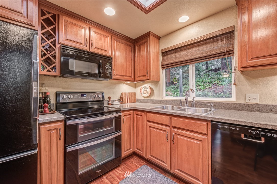 2001 172nd Place Southeast Bothell, WA 98012 - Photo 7 of 32 a kitchen with stainless steel appliances granite countertop wooden cabinets a stove a sink and a microwave