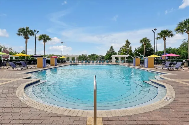 a view of a house with a swimming pool and sitting area