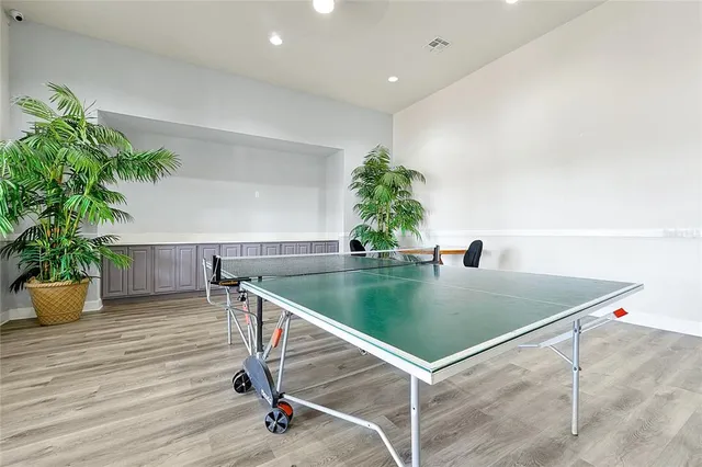 a room with furniture pool table wooden floor and view living room