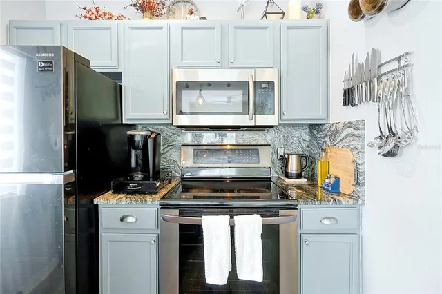 a kitchen with stainless steel appliances a stove microwave and refrigerator