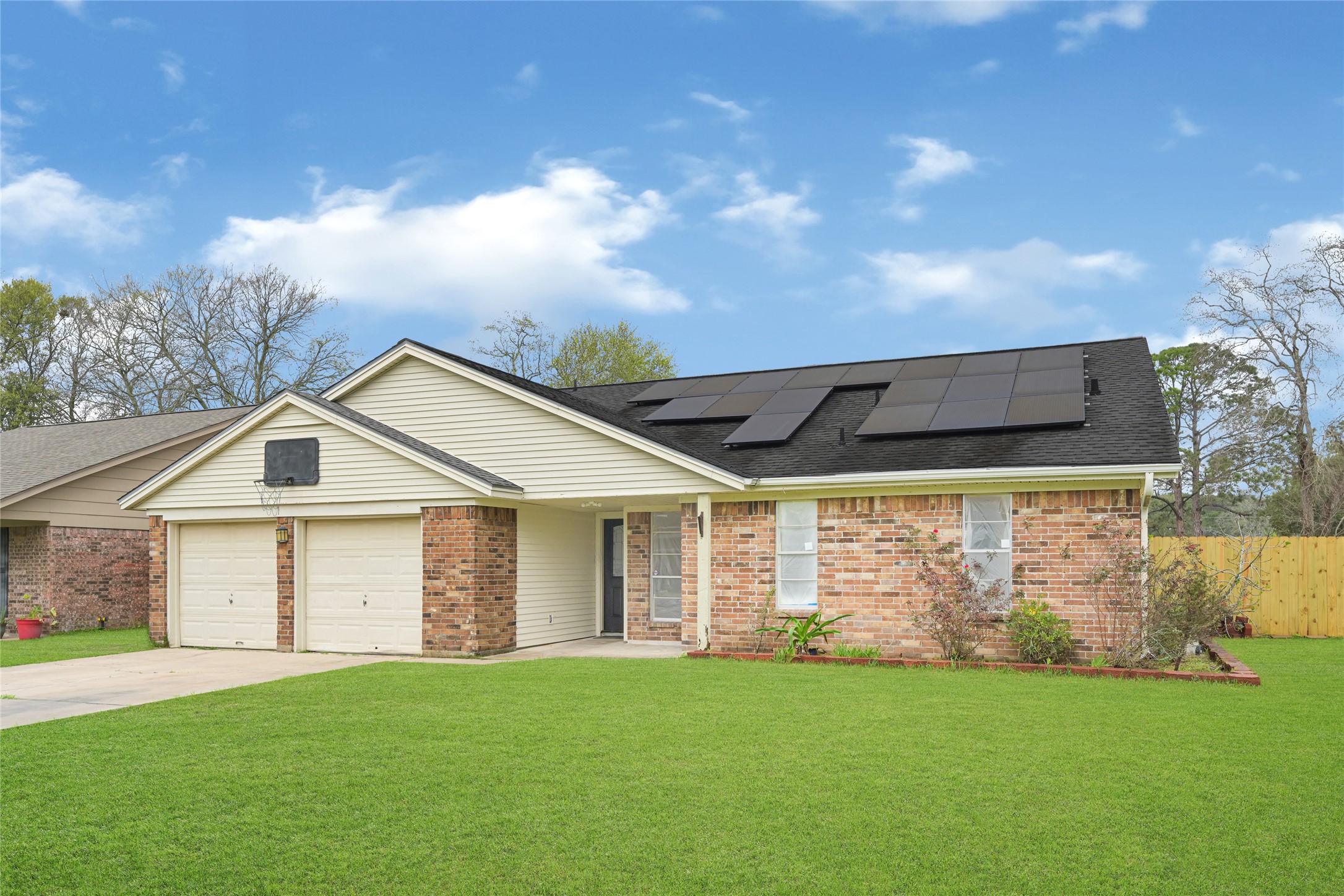 Charming exterior with a wide driveway, mature trees, and a welcoming front presence in an established neighborhood.