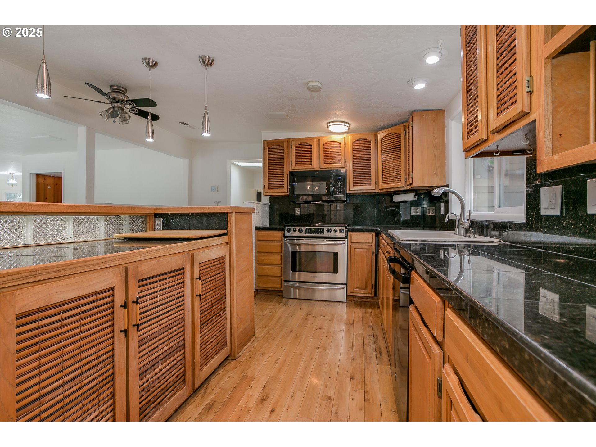 1755 East 43rd Avenue Eugene, OR 97405 - Photo 16 of 34 a kitchen with stainless steel appliances granite countertop a stove a sink dishwasher and a microwave oven with cabinets