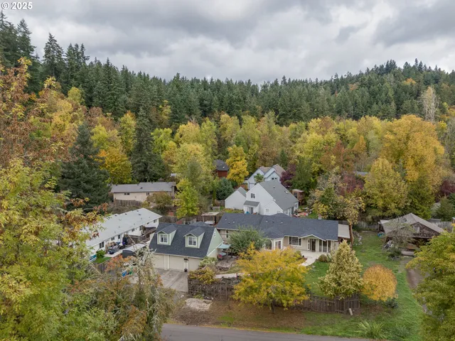 an aerial view of a house with a garden and lake view