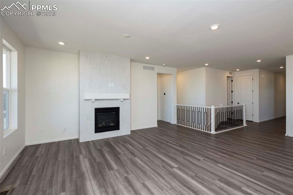 2120 Peachleaf Loop Castle Rock, CO 80108 - Photo 11 of 28 an empty room with wooden floor fireplace and windows