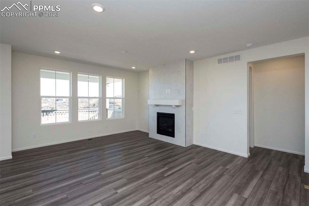 2120 Peachleaf Loop Castle Rock, CO 80108 - Photo 15 of 28 a view of empty room with wooden floor and fireplace