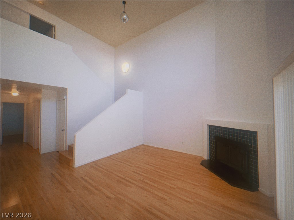 6250 West Flamingo Road, Unit 60 Las Vegas, NV 89103 - Photo 3 of 23 This living space features warm hardwood floors, an integrated staircase, and a corner fireplace with tiled surround.