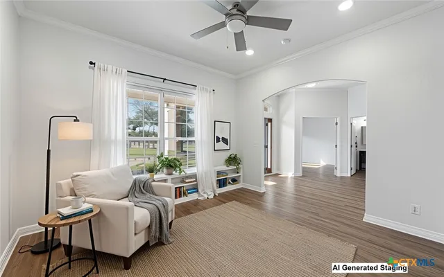 an empty room with wooden floor chandelier fan and windows