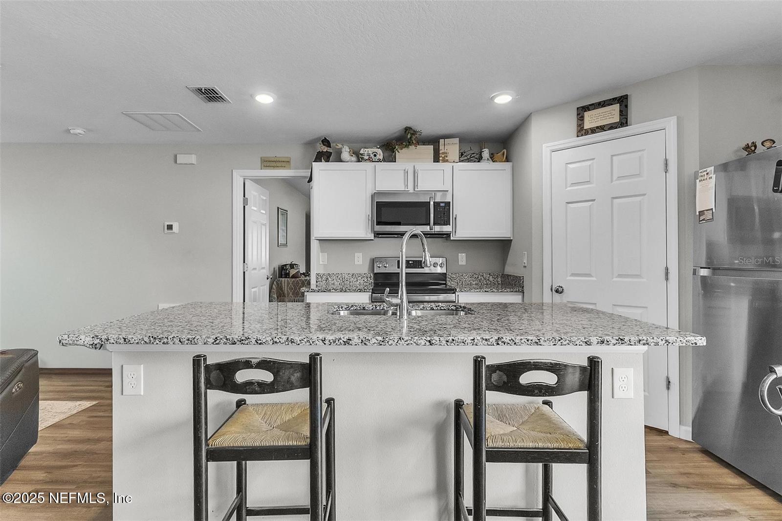 19 Ruth Drive Palm Coast, FL 32164 - Photo 8 of 23 a kitchen with stainless steel appliances granite countertop a stove a sink and a refrigerator