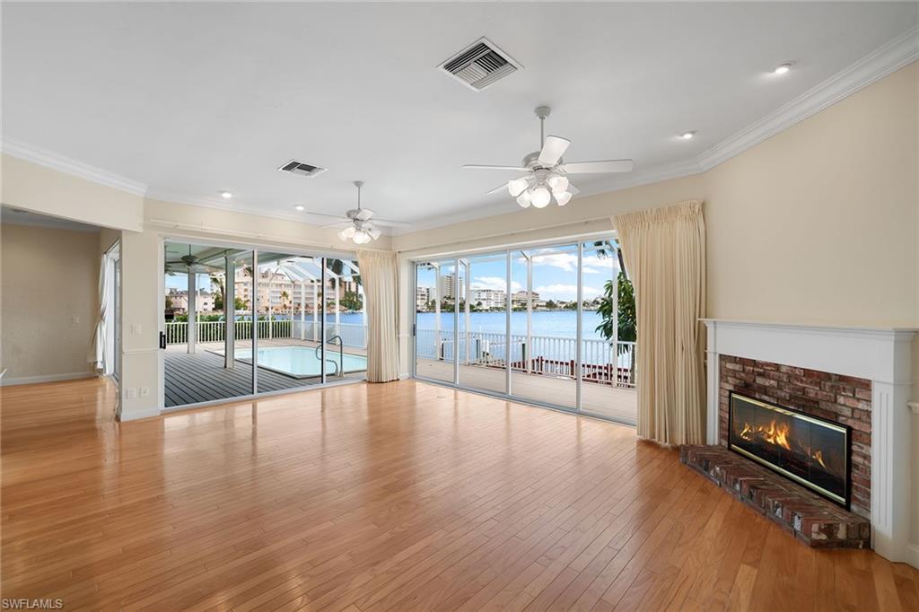 283 Oak Avenue Naples, FL 34108 - Photo 15 of 39 an empty room with wooden floor fireplace and windows