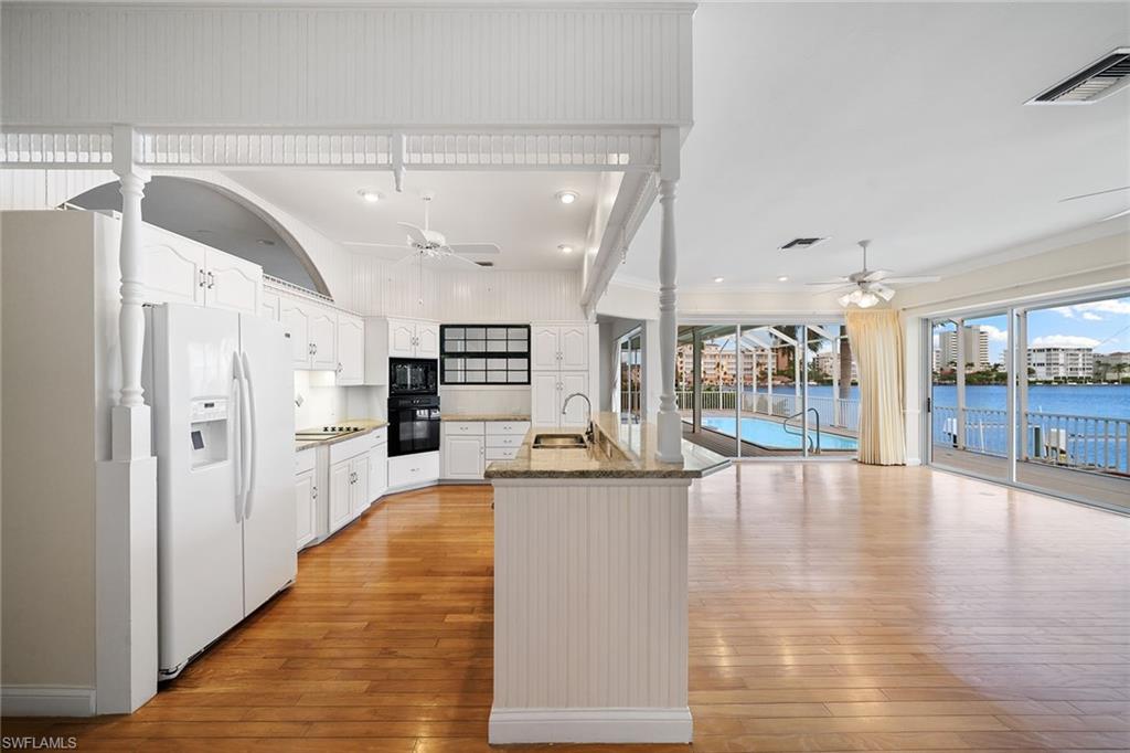 283 Oak Avenue Naples, FL 34108 - Photo 21 of 39 a large white kitchen with cabinets and wooden floor