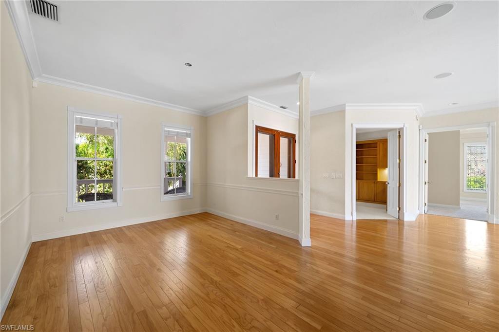283 Oak Avenue Naples, FL 34108 - Photo 10 of 39 an empty room with wooden floor and windows