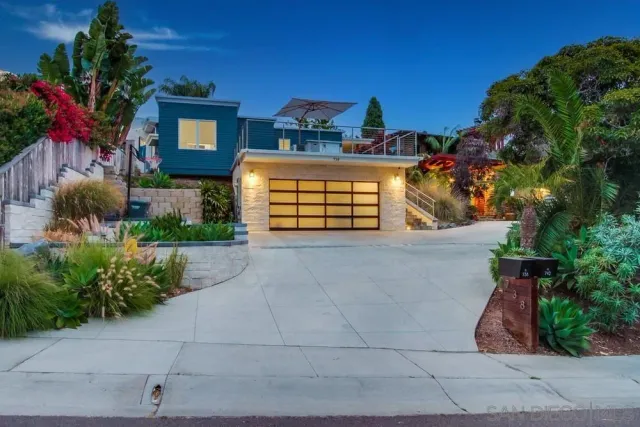 a view of a house with a yard and potted plants