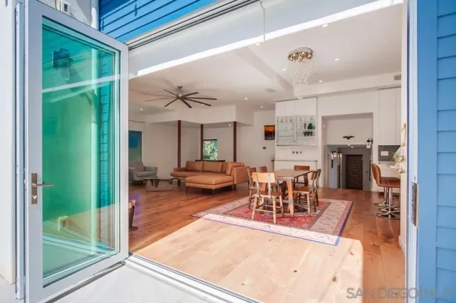 a living room with furniture a table and kitchen view