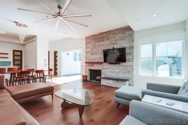 a living room with furniture a fireplace a flat screen tv and a large window