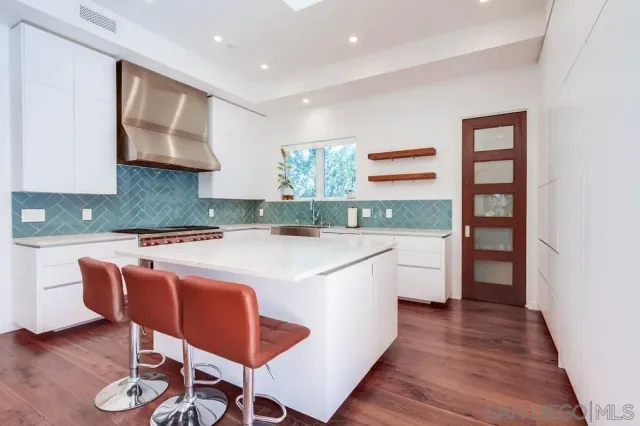 a kitchen that has a lot of cabinets in it with stainless steel appliances granite countertop a stove a sink and a refrigerator