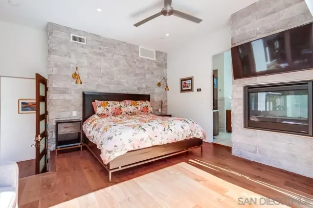 a bed sitting in a bedroom next to a window with pc on the wall