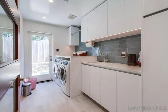 a utility room with sink dryer and washer