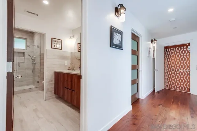 a view of hallway with a door and wooden floor