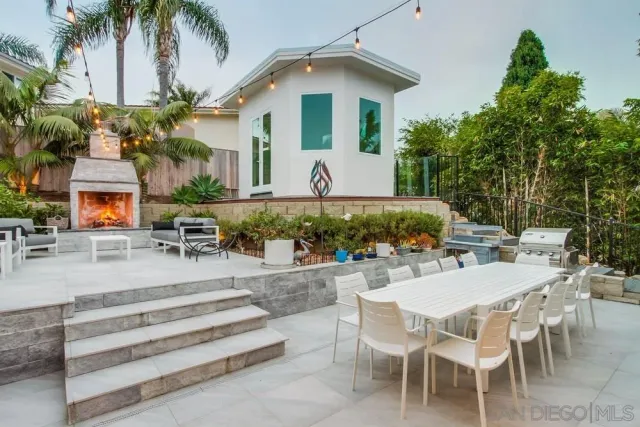 a view of a white house with a yard patio and swimming pool
