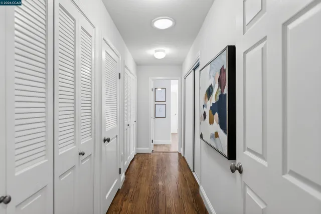 a view of a hallway with wooden floor and staircase