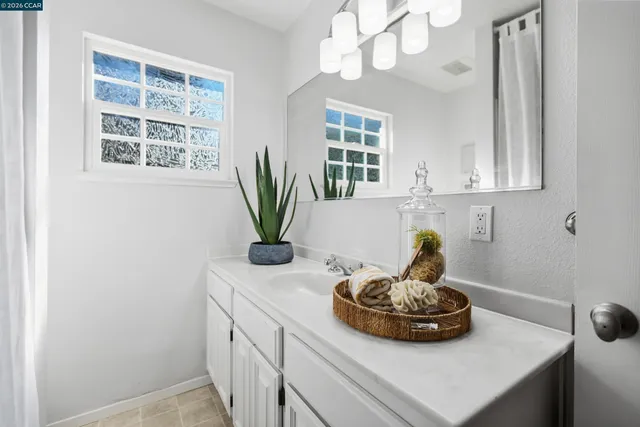 a bathroom with a sink a large mirror and a window