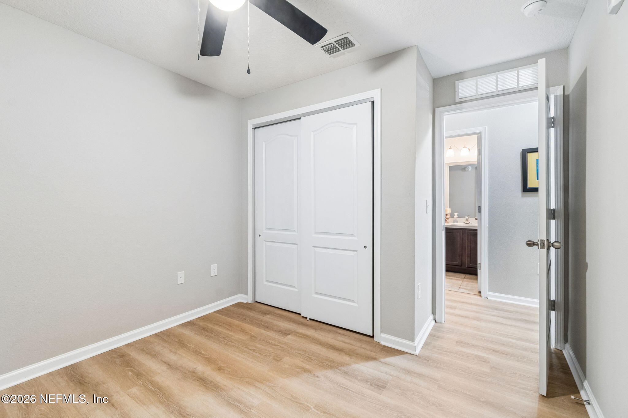 2113 Golden Lake Loop St. Augustine, FL 32084 - Photo 26 of 50 an empty room with wooden floor a chandelier fan and windows
