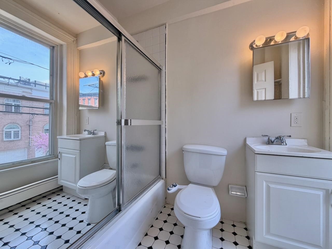 415 1st Street, Unit 2R Hoboken, NJ 07030 - Photo 11 of 22 a bathroom with a toilet a sink and a mirror