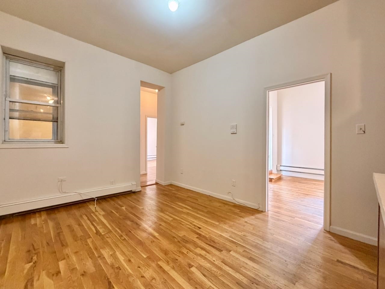 415 1st Street, Unit 2R Hoboken, NJ 07030 - Photo 3 of 22 an empty room with wooden floor and windows