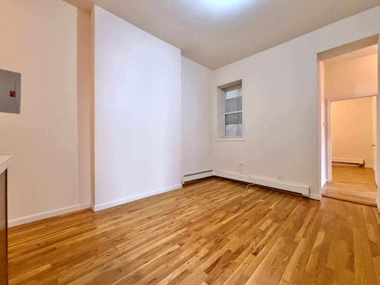 415 1st Street, Unit 2R Hoboken, NJ 07030 - Photo 4 of 22 an empty room with wooden floor and windows