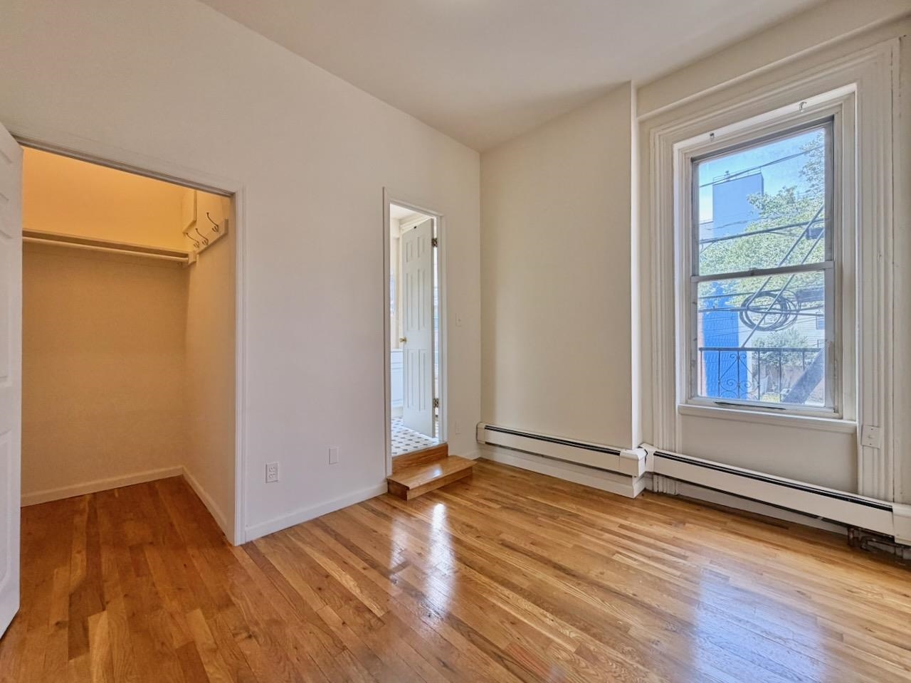 415 1st Street, Unit 2R Hoboken, NJ 07030 - Photo 7 of 22 an empty room with wooden floor and windows