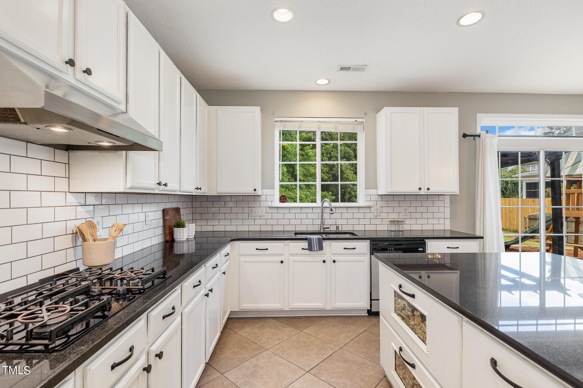 8814 Elizabeth Bennet Place Raleigh, NC 27616 - Photo 12 of 28 a kitchen with a sink stove top oven and cabinets