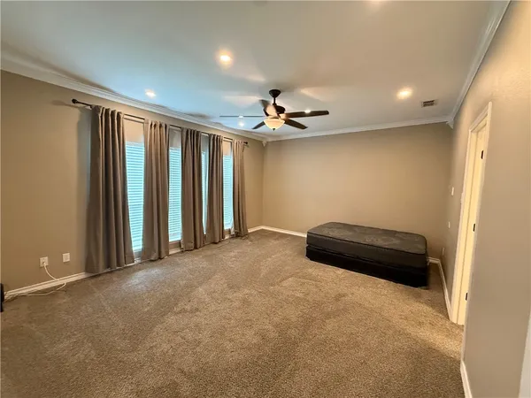 an empty room with a ceiling fan and window
