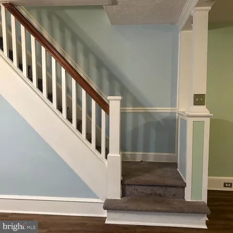 a view of staircase with lots of frames on wall and a window