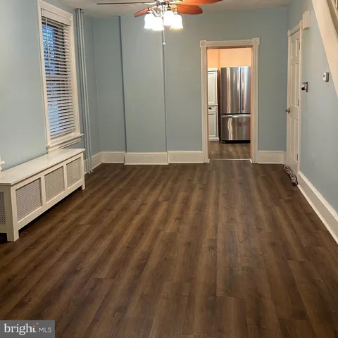 a view of a livingroom with wooden floor and staircase