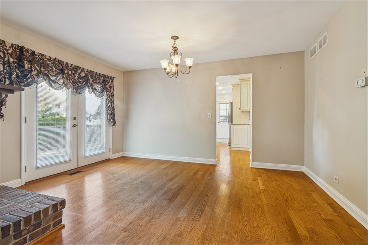 417 River Bluff Circle Naperville, IL 60540 - Photo 4 of 20 a view of an empty room with wooden floor and a window