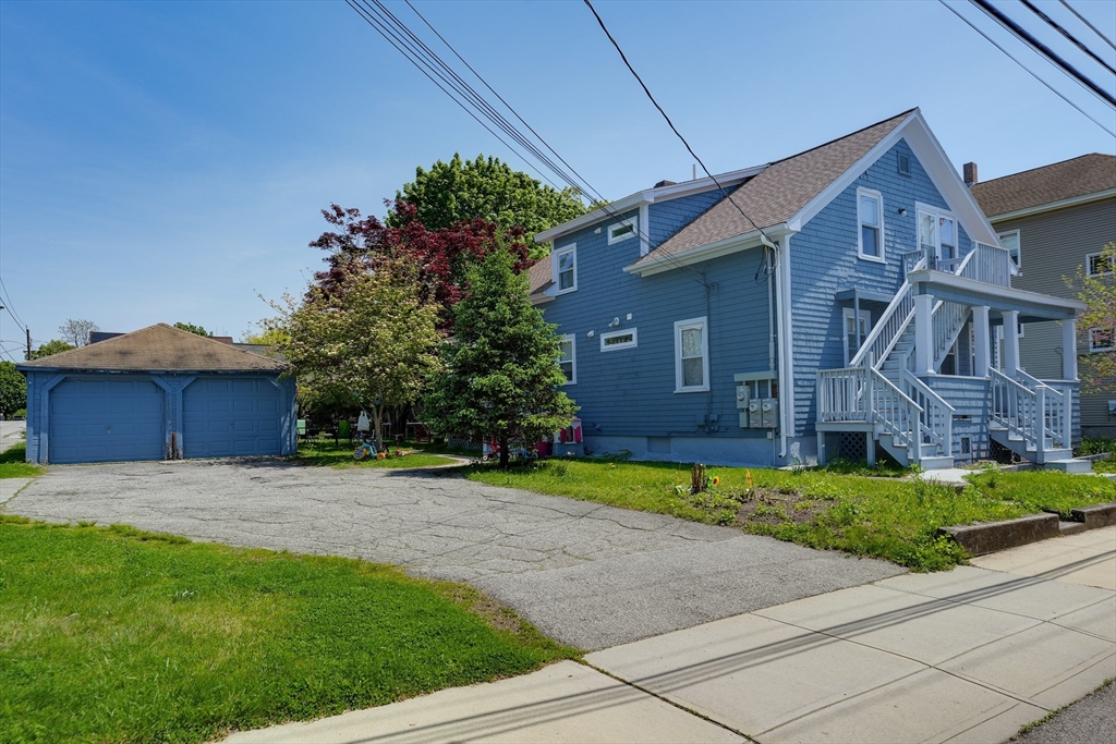 5 Eddy Street, Unit 2 Webster, MA 01570 - Photo 5 of 18 a front view of a house with a yard and garage