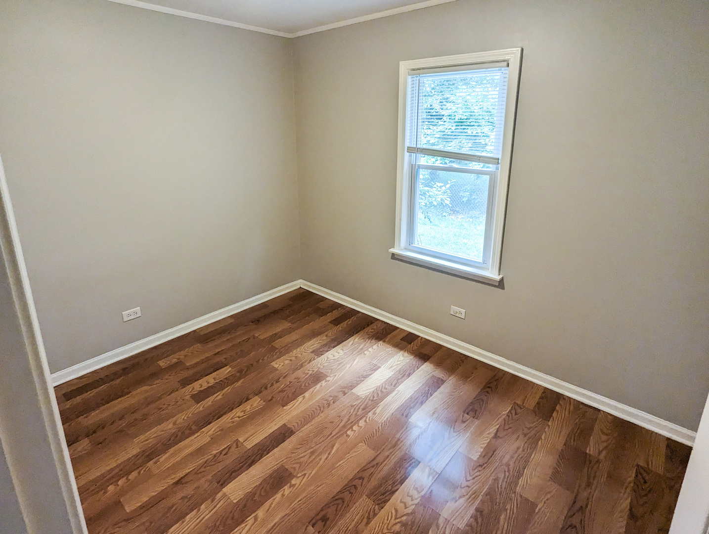 1369 North Quentin Road Palatine, IL 60067 - Photo 6 of 12 a view of an empty room with wooden floor and a window