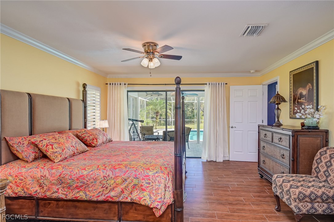 4601 Orange River Loop Road Fort Myers, FL 33905 - Photo 18 of 50 a bedroom with a large bed and a chandelier