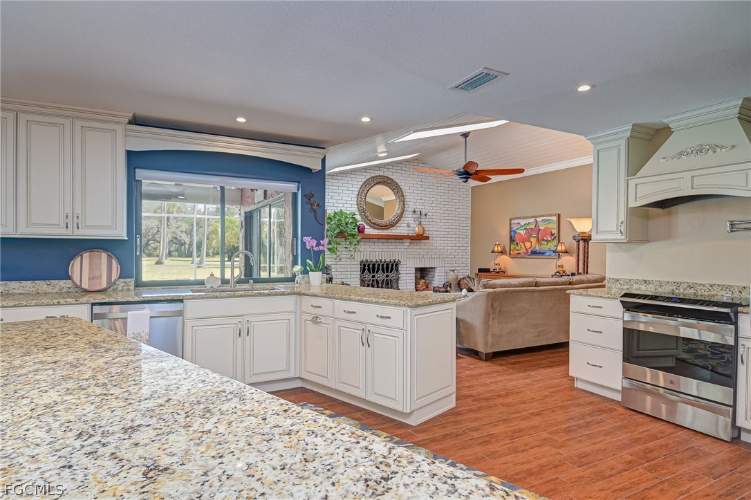 4601 Orange River Loop Road Fort Myers, FL 33905 - Photo 28 of 50 a kitchen with stainless steel appliances granite countertop a stove a sink and a refrigerator