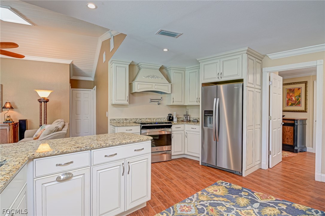 4601 Orange River Loop Road Fort Myers, FL 33905 - Photo 29 of 50 a kitchen with stainless steel appliances granite countertop a refrigerator and a stove top oven