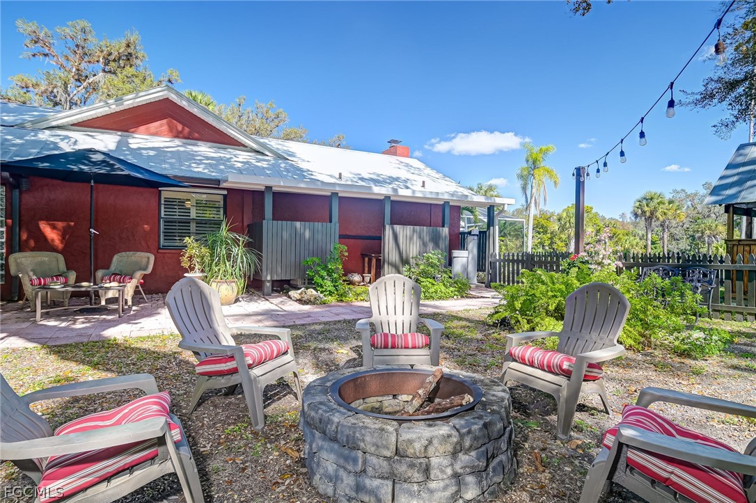 4601 Orange River Loop Road Fort Myers, FL 33905 - Photo 50 of 50 a view of a patio with table and chairs potted plants and palm tree